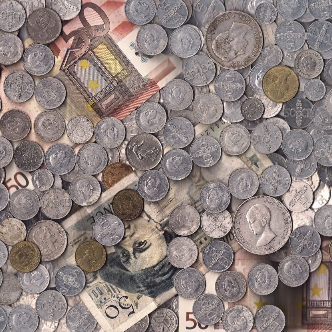 A collection of various European currency coins and notes in a scattered arrangement.