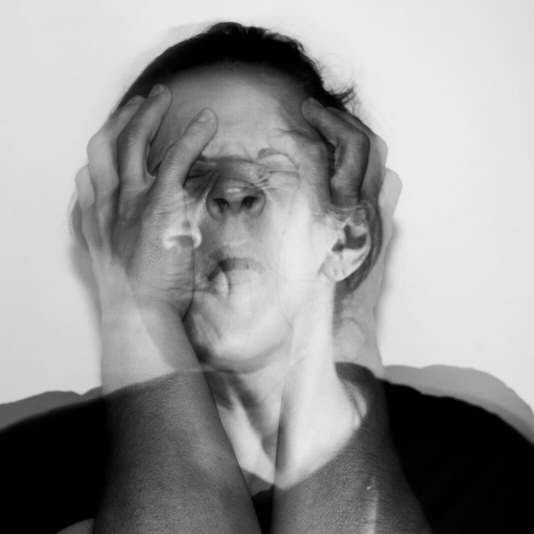 Black and white portrait capturing intense emotion through double exposure technique.