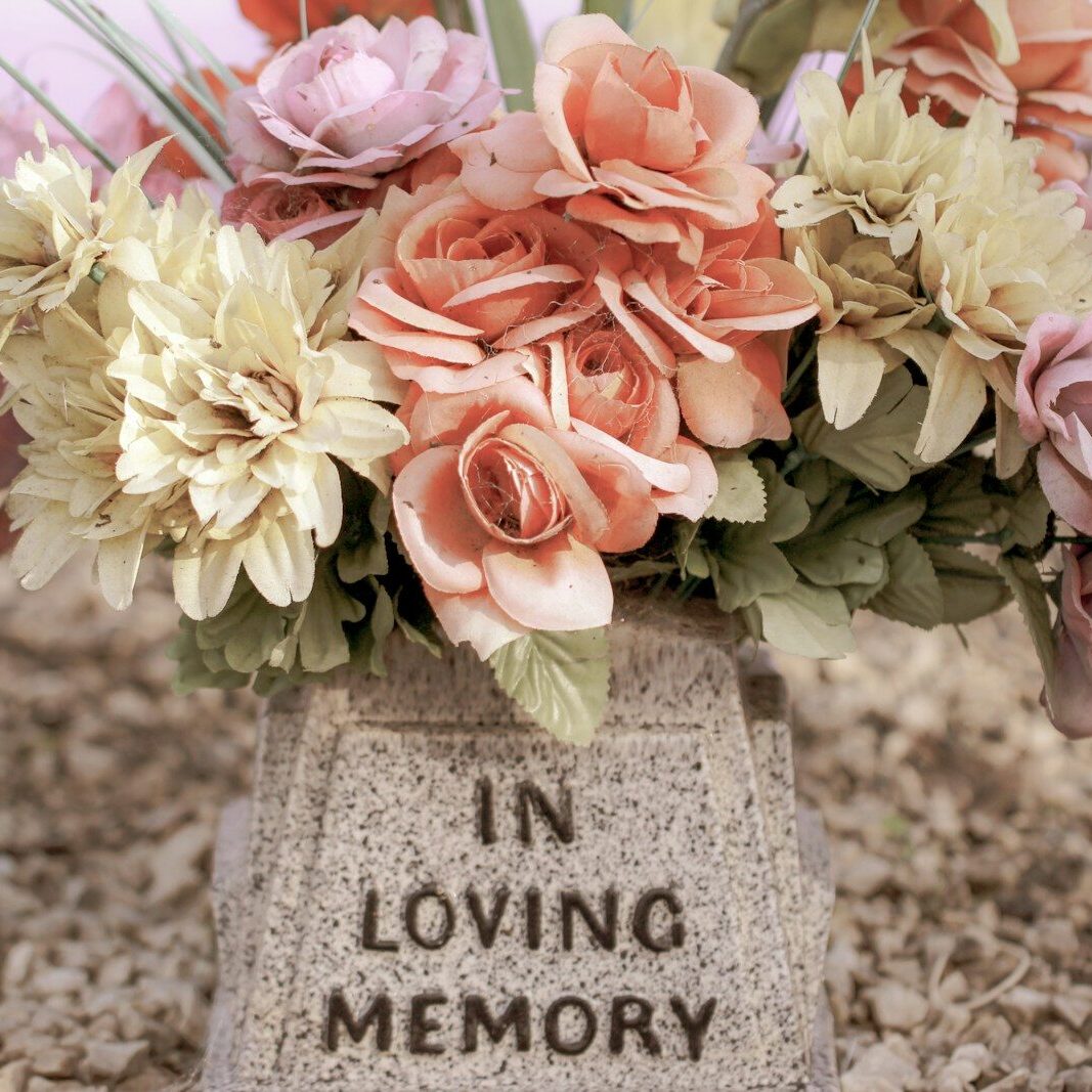 pink and white flowers on gray concrete tomb